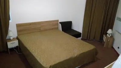 a small bedroom with a bed and a chair at Villa Bojinovi - Forest Nook 2 in Pamporovo