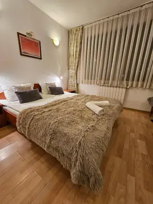 a bedroom with a bed with two towels on it at Guest House Karov - 2 Stars in Chepelare