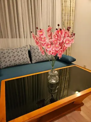 a vase with pink flowers sitting on a table at Guest House Karov - 2 Stars in Chepelare