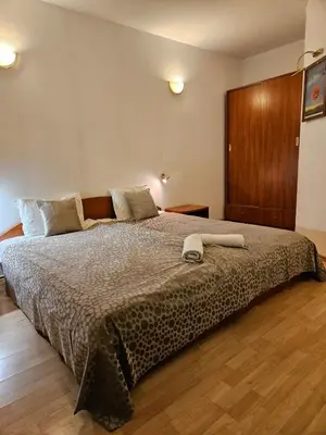 a bedroom with a large bed with a wooden floor at Guest House Karov - 2 Stars in Chepelare
