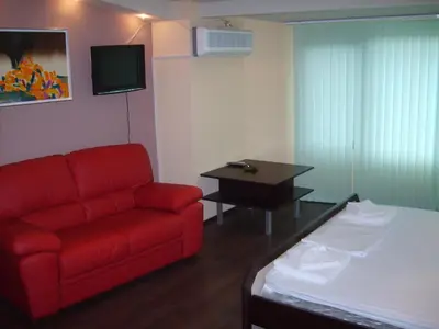 a living room with a red couch and a table at Hotel Trakart Residence in Plovdiv
