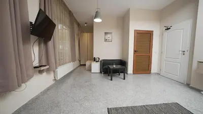 a living room with a tv and a chair and a door at Mini Sofia in Sofia