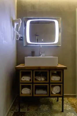 a bathroom with a sink and a mirror and towels at HOTEL FINIX CASINO in Kulata