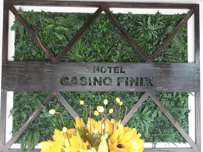 a sign that reads hotel casting firm with yellow flowers at HOTEL FINIX CASINO in Kulata