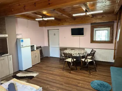 a dining room with a table and chairs and a kitchen at Borovets Gondola Apartment & Ski by Winter Bros in Borovets