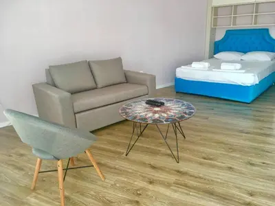 a living room with a couch and a table and a bed at Bluemarine Apartment in Sofia