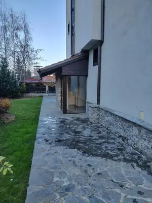 a house with a stone walkway next to a building at Mountain Escape Bansko 1BR apartment in Bansko