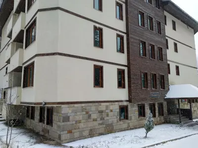 an apartment building with snow on the ground at Evrika Forest in Pamporovo