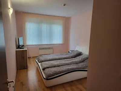 a bedroom with a bed and a television and a window at Evrika Forest in Pamporovo