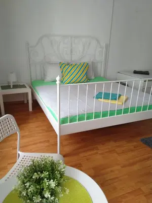 a small white bed in a room with a table at Sofia Peak in Sofia