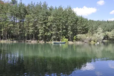 a person in a boat on a lake at Strandzhata's House in Pasarel