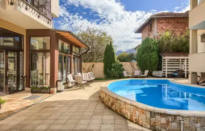 a swimming pool in a yard next to a house at Family Hotel Zornitsa in Ribarica