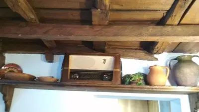 an old radio sitting on a shelf with vases at Боримечковата къща in Kalofer