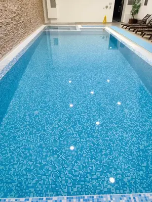 a swimming pool with blue tiles on the floor at F307 Studio Aspen Golf Resort Bansko in Bansko