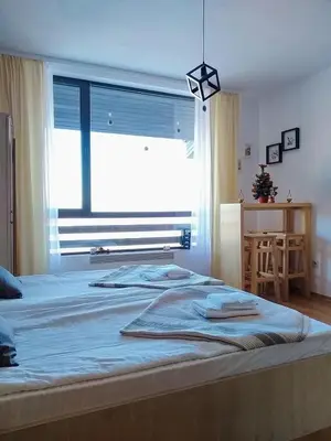 a bedroom with a large bed with a large window at F307 Studio Aspen Golf Resort Bansko in Bansko