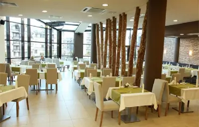 a dining room with white tables and chairs at F307 Studio Aspen Golf Resort Bansko in Bansko