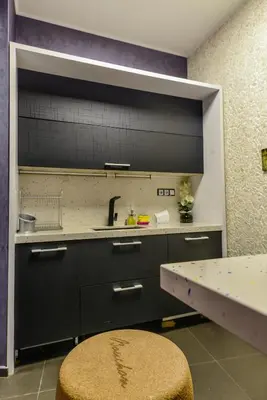 a kitchen with black cabinets and a sink and a table at Champs-Élysées Sofia 2-BDR, 2-BTHR Tsar Simeon Suite by Flat Mаnager in Sofia
