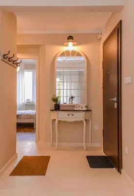a hallway with a table with a mirror and a window at cО́coEllie - Aesthetic 2BD Apt Near National Palace by Flat Mаnager in Sofia