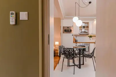 a dining room and kitchen with a table and chairs at cО́coEllie - Aesthetic 2BD Apt Near National Palace by Flat Mаnager in Sofia