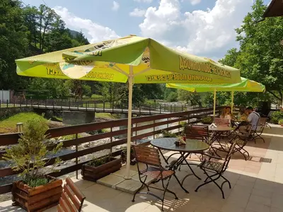 a table and chairs under an umbrella on a patio at Family Hotel Fedora in Ribarica