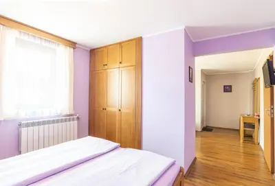 a bedroom with a bed and a wooden cabinet at Guest House Roden Dom in Koprivshtitsa