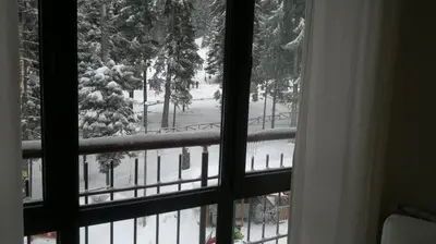 a window with a view of a snow covered yard at Borovets Holiday Apartments - Different Locations in Borovets in Borovets