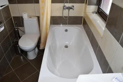 a bathroom with a white tub and a toilet at Borovets Holiday Apartments - Different Locations in Borovets in Borovets