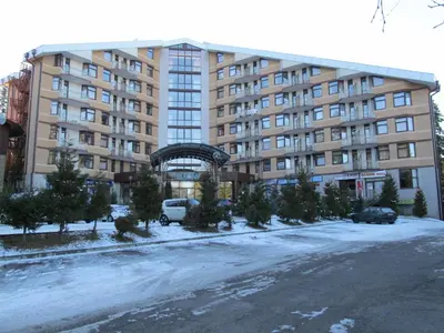 a large building with a snowy street in front of it at Borovets Holiday Apartments - Different Locations in Borovets in Borovets