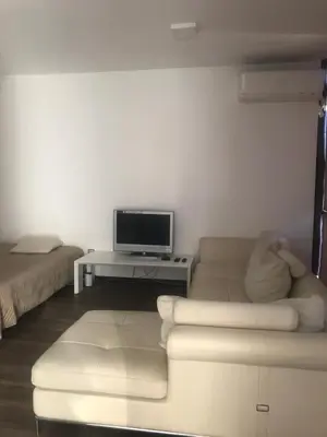 a living room with a couch and a tv at Lilia 2 Self-Check in apartment in Sofia