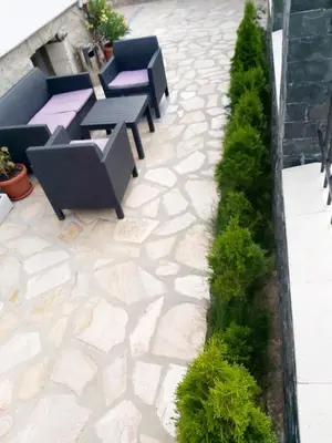 a patio with chairs and tables and plants at Sharkova House Bansko in Bansko