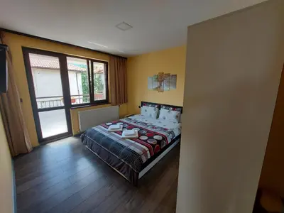 a bedroom with a bed and a large window at Sharkova House Bansko in Bansko
