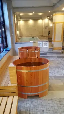 a large wooden tub in a room with benches at 7 Pools SPA Boutique Hotel in Bansko