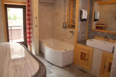 a bathroom with a bath tub and a sink at 7 Pools SPA Boutique Hotel in Bansko