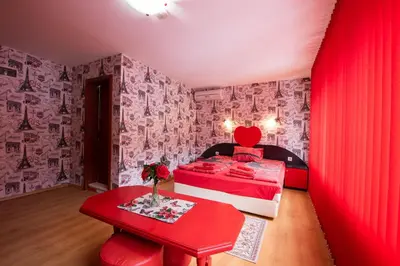 a red bedroom with a red bed and a red table at Family Hotel Enica in Teteven