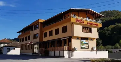 a building with a sign on the side of it at Family Hotel Enica in Teteven