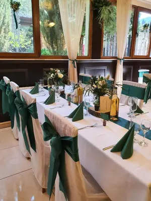 a long table with green bows in a room at Family Hotel Enica in Teteven