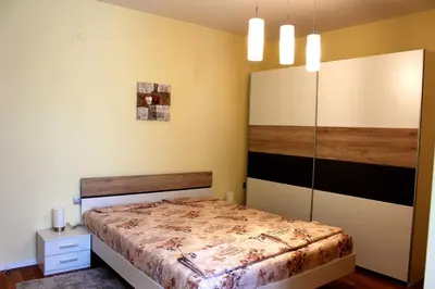 a bedroom with a bed and a cabinet in it at Venice Apartments in Sofia