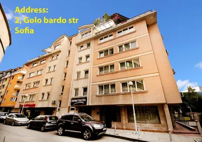a building with cars parked in front of it at Venice Apartments in Sofia