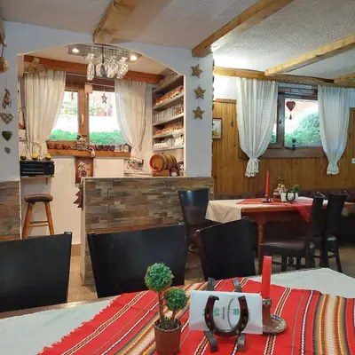 a dining room with a table and chairs and a table and chairsktop at Guest House Planinski Zdravets in Bansko