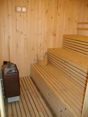 a room with a wood paneled room with a bed and a tub at Guest House Planinski Zdravets in Bansko