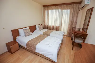 a hotel room with two beds and a desk at Къща за гости 