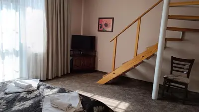 a bedroom with a staircase and a bed and a television at Hotel St. George Pobedonosets in Bansko