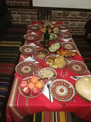 a table with a red table cloth with food on it at Hotel St. George Pobedonosets in Bansko