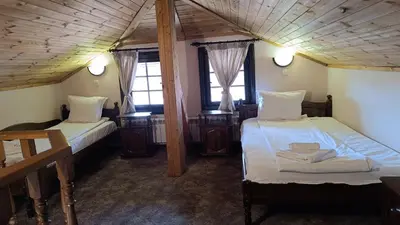 a room with two beds and two windows at Hotel St. George Pobedonosets in Bansko