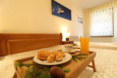 a tray with a plate of food on a bed at Pine Tree Apartment 2 - B7 in Bansko