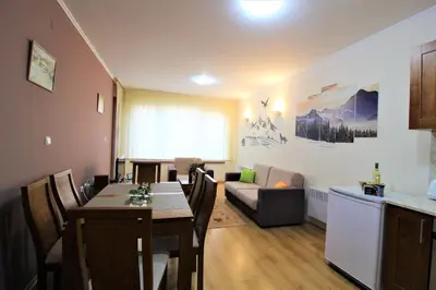 a kitchen and living room with a table and a couch at Pine Tree Apartment 2 - B7 in Bansko
