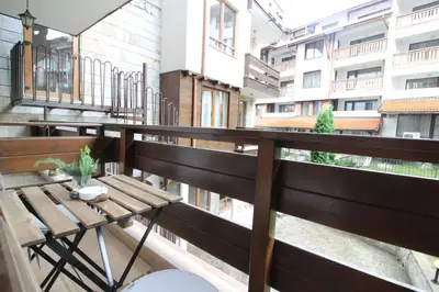 a balcony with a wooden table and a bench at Pine Tree Apartment 3 - B3 in Bansko
