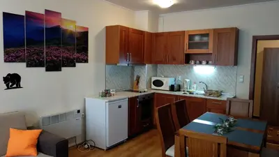 a kitchen with a white refrigerator and a table at Pine Tree Apartment 3 - B3 in Bansko
