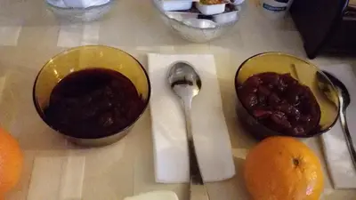 a table with two bowls of jam and a spoon at Guest House Ilinden in Bansko