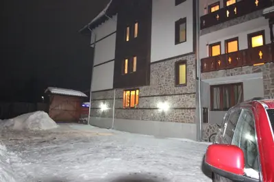 a building with snow in front of it at night at Guest House Ilinden in Bansko
